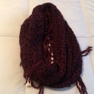 Burgundy and black knitted infinity scarf with fringes.